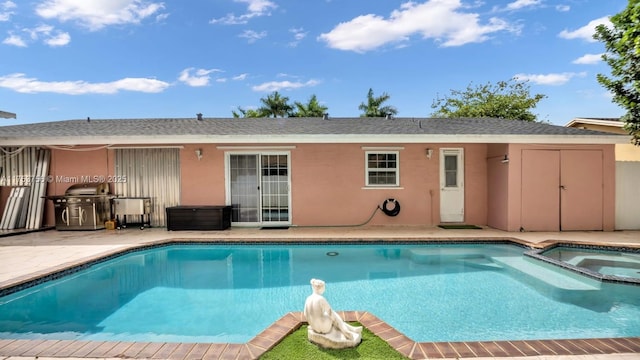 view of pool featuring a patio area, a pool with connected hot tub, and grilling area