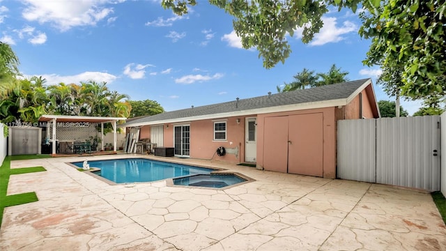 view of pool with a patio area, a pool with connected hot tub, and fence