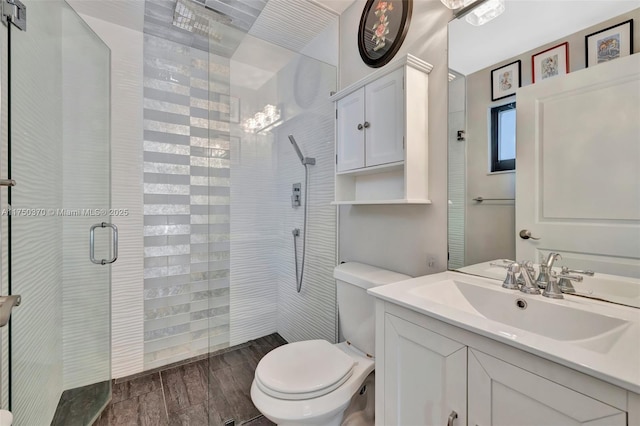 bathroom with a stall shower, vanity, toilet, and wood tiled floor