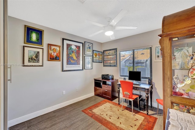 office space featuring a textured ceiling, wood finished floors, a ceiling fan, and baseboards