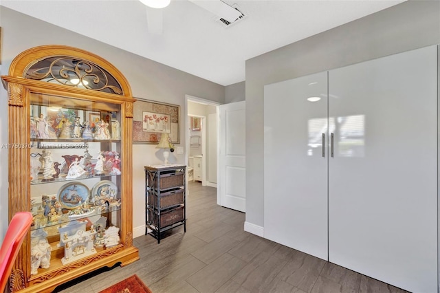 hallway featuring dark wood-style floors, visible vents, and baseboards