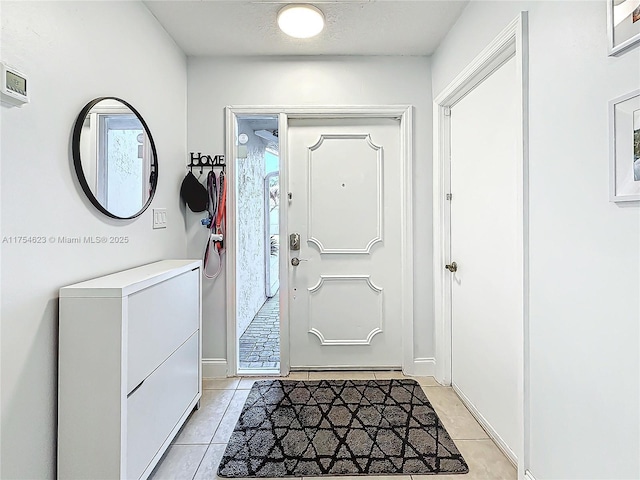 foyer featuring a textured ceiling and light tile patterned floors