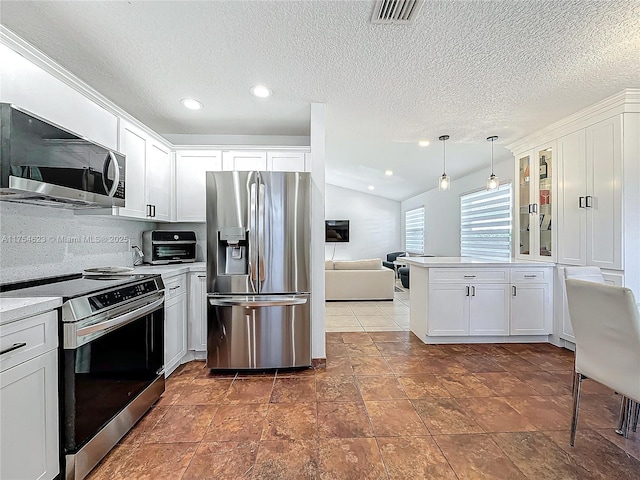 kitchen featuring visible vents, lofted ceiling, glass insert cabinets, stainless steel appliances, and light countertops