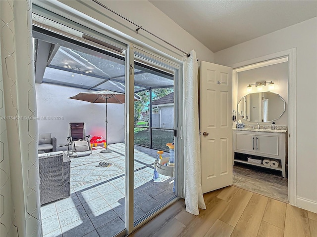 entryway featuring light wood finished floors and a sink