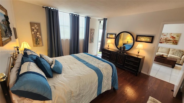 bedroom with baseboards, wood finished floors, and floor to ceiling windows