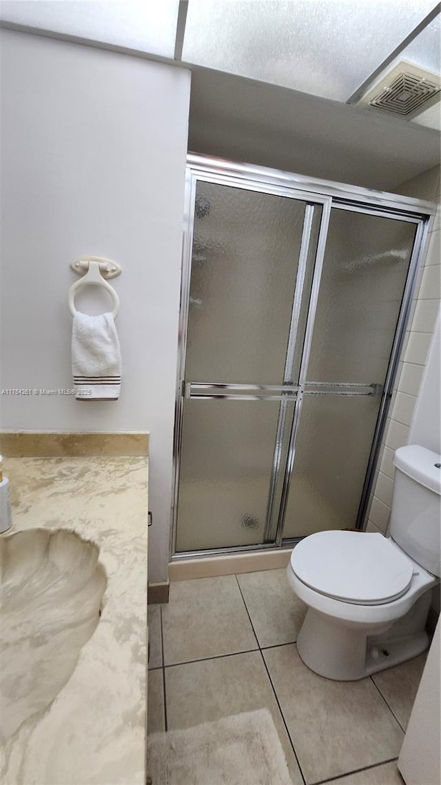 full bathroom featuring toilet, a stall shower, visible vents, and tile patterned floors