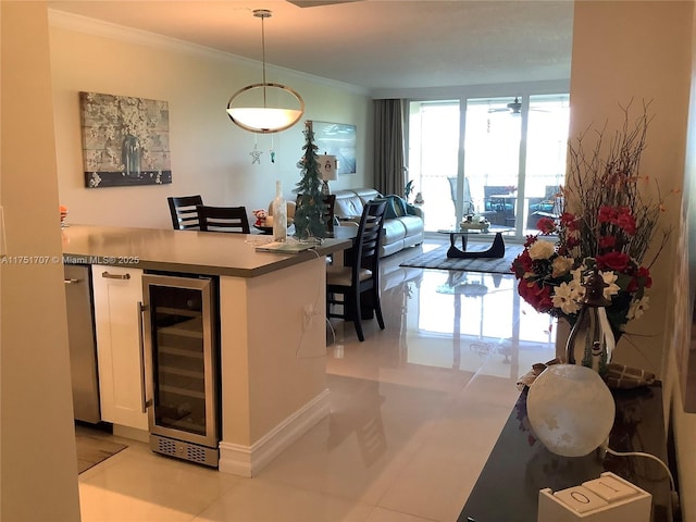 kitchen with crown molding, hanging light fixtures, open floor plan, white cabinets, and beverage cooler