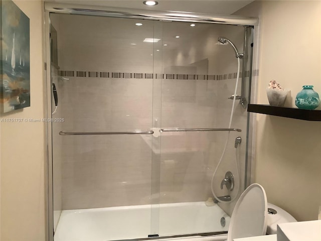 full bath featuring shower / bath combination with glass door and toilet