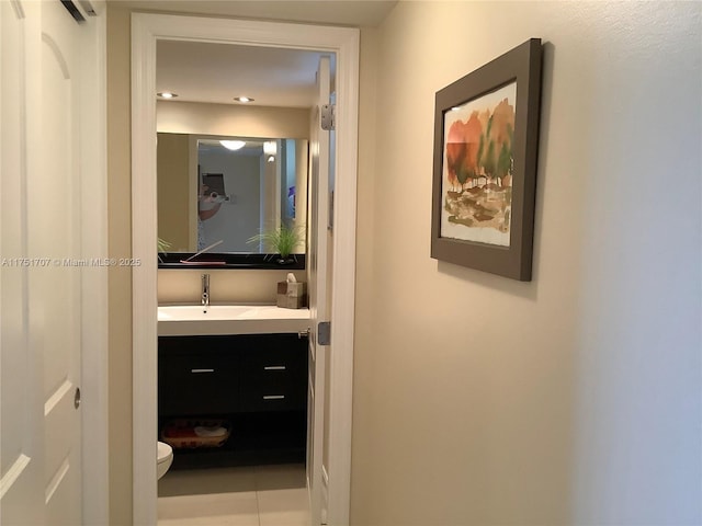 hallway with tile patterned flooring and a sink