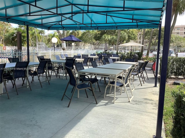 view of patio featuring outdoor dining area and fence