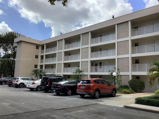 view of building exterior with uncovered parking