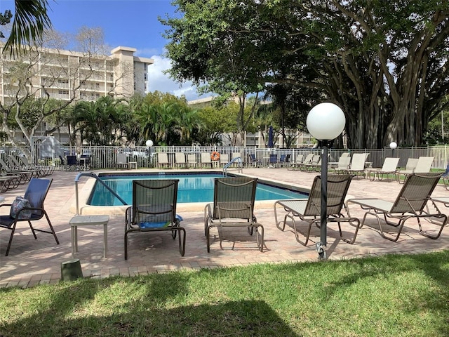 pool with a patio area and fence