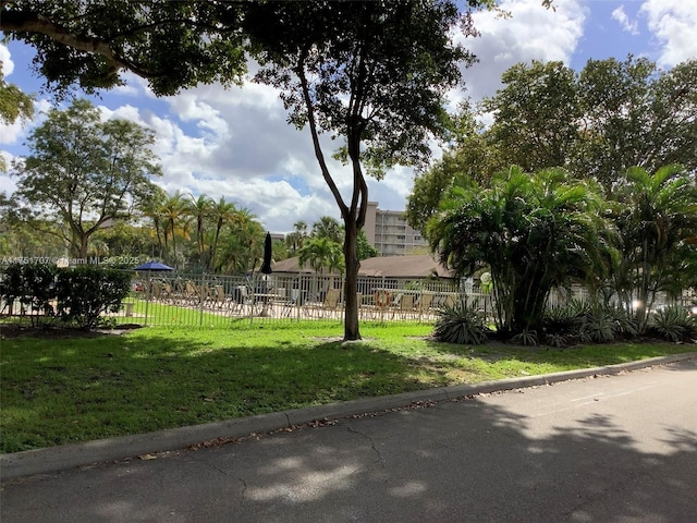 view of property's community featuring fence and a yard