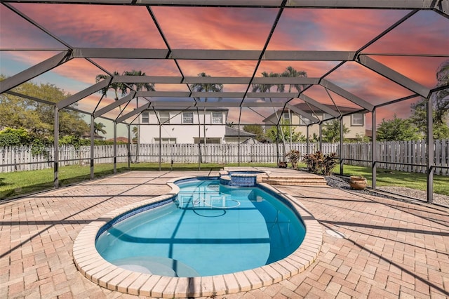 view of pool with a patio, a fenced backyard, a pool with connected hot tub, and a lanai