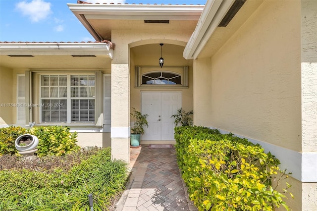 view of exterior entry with stucco siding