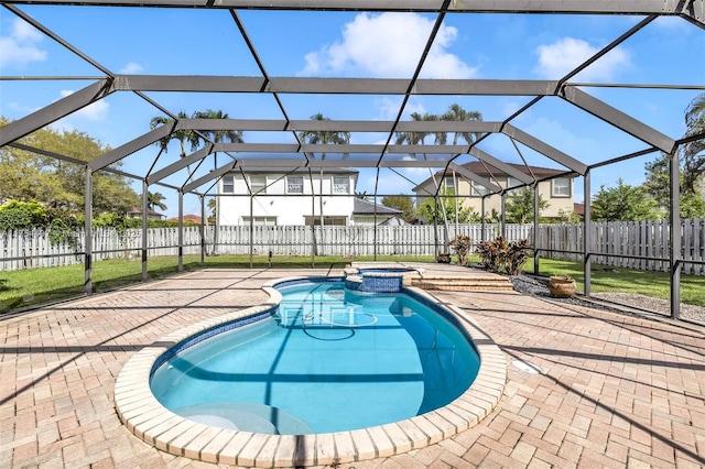 view of swimming pool with glass enclosure, a patio area, a fenced backyard, and a pool with connected hot tub