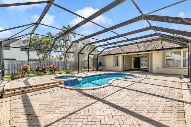 view of pool with a patio, a pool with connected hot tub, a ceiling fan, glass enclosure, and fence