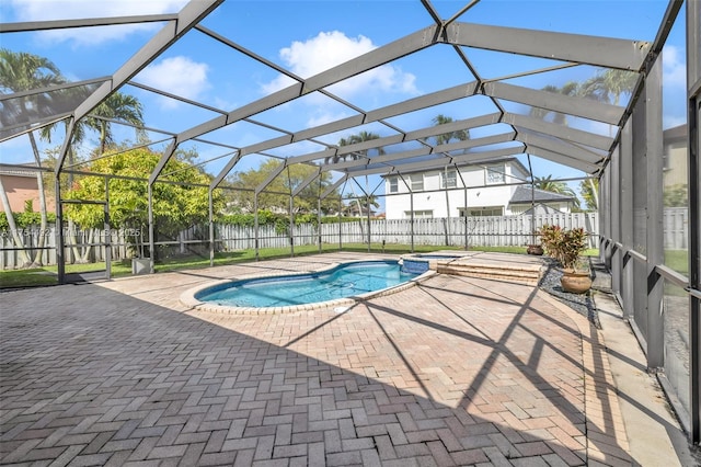 view of pool with a patio, a fenced backyard, a pool with connected hot tub, and a lanai