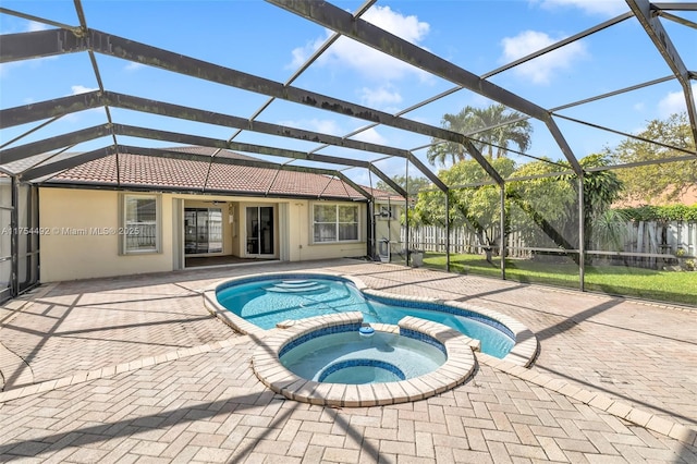 view of swimming pool featuring a patio, glass enclosure, and a pool with connected hot tub