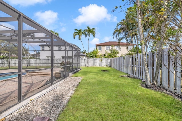 view of yard featuring a patio area, a fenced backyard, and a lanai