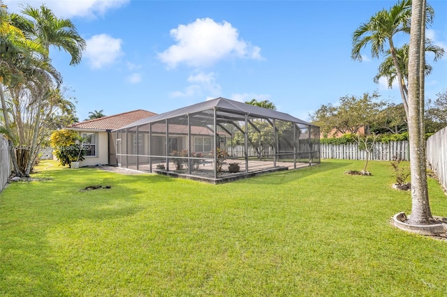 view of yard featuring glass enclosure and a fenced backyard