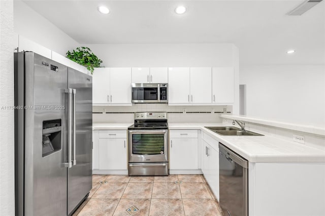 kitchen featuring a sink, visible vents, white cabinetry, appliances with stainless steel finishes, and backsplash