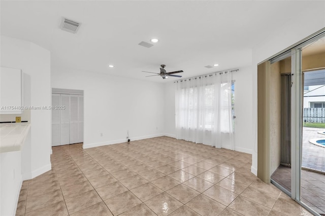 unfurnished room featuring light tile patterned floors, recessed lighting, visible vents, a ceiling fan, and baseboards