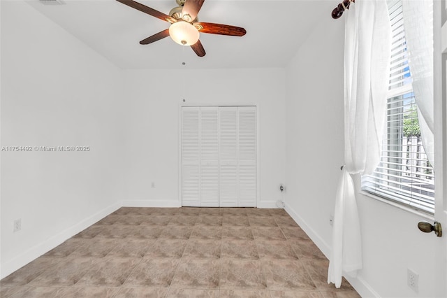 unfurnished bedroom with ceiling fan, a closet, and baseboards