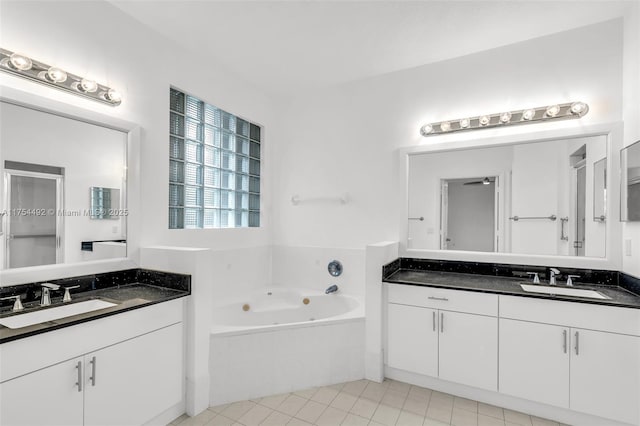 bathroom featuring a bath, two vanities, a sink, and tile patterned floors