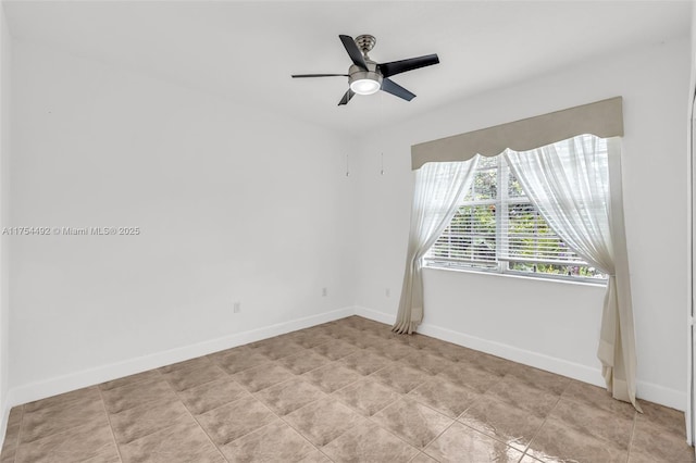 spare room with baseboards, a ceiling fan, and light tile patterned flooring