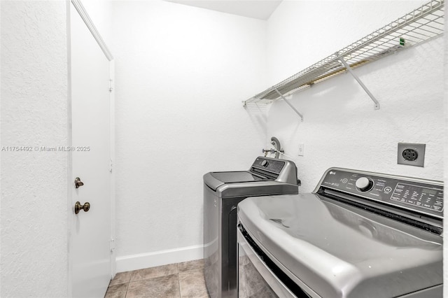 laundry room featuring laundry area, independent washer and dryer, light tile patterned flooring, and baseboards