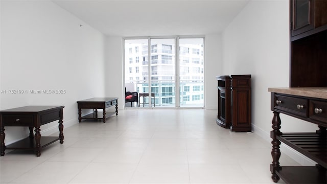 living area with baseboards and a wall of windows