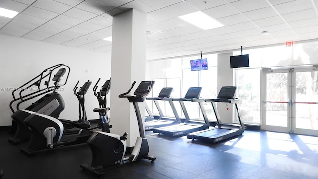 gym with french doors, a drop ceiling, and floor to ceiling windows