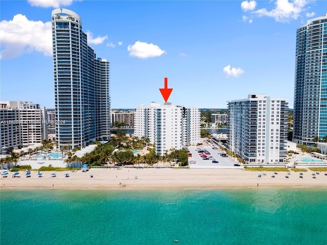 birds eye view of property with a water view, a view of city, and a beach view
