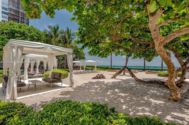 view of property's community featuring a water view, a patio area, and a gazebo