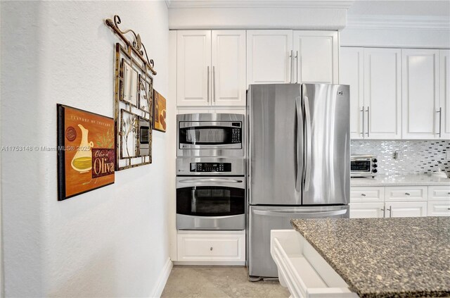 1468 Mariner Way, Hollywood, FL 33019 - kitchen with appliances with stainless steel finishes, ornamental molding, white cabinetry, dark stone countertops, and backsplash