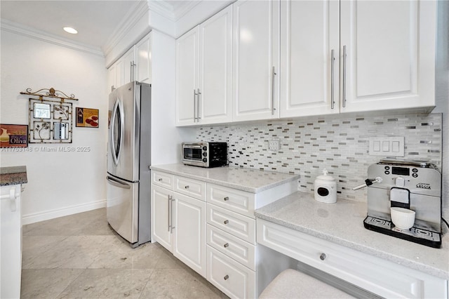 1468 Mariner Way, Hollywood, FL 33019 - kitchen with freestanding refrigerator, ornamental molding, white cabinets, decorative backsplash, and light stone countertops