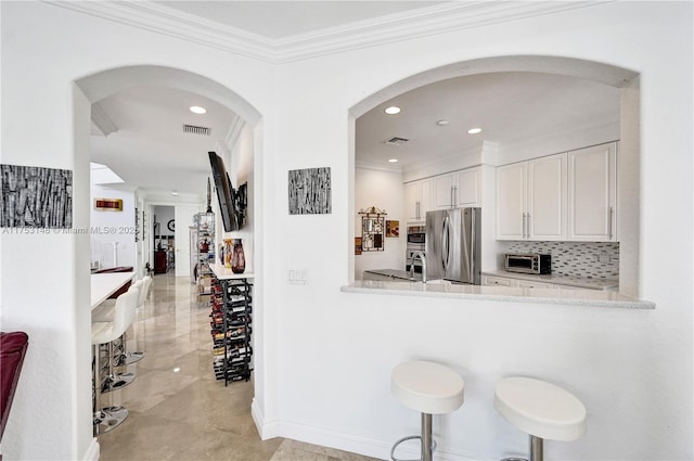 1468 Mariner Way, Hollywood, FL 33019 - kitchen with freestanding refrigerator, ornamental molding, light countertops, white cabinets, and recessed lighting