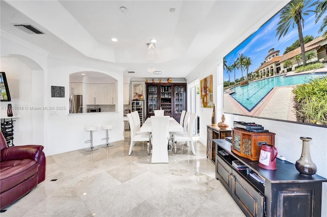 1468 Mariner Way, Hollywood, FL 33019 - dining space featuring a raised ceiling, arched walkways, crown molding, and recessed lighting
