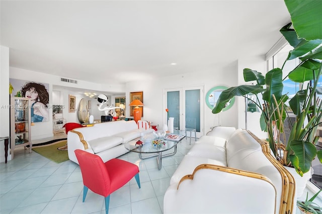 living area featuring a chandelier, french doors, tile patterned flooring, and visible vents