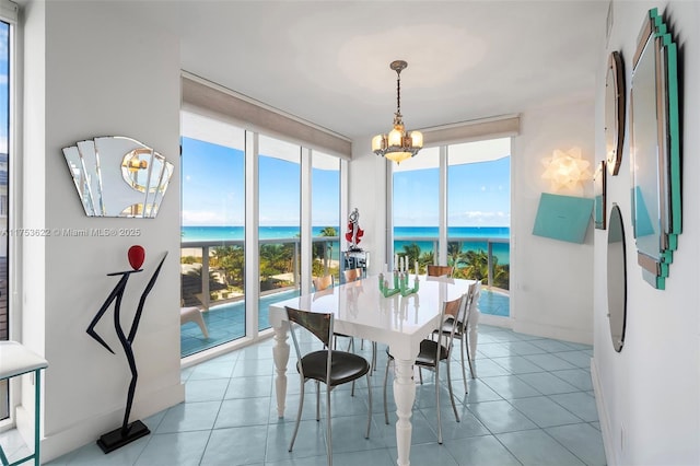 tiled dining space featuring a water view, plenty of natural light, expansive windows, and baseboards