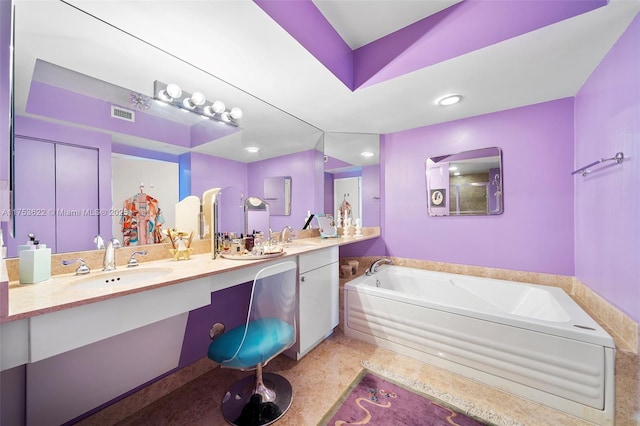 bathroom featuring double vanity, a garden tub, visible vents, and a sink