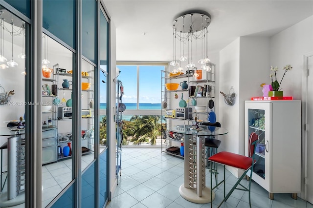 interior space featuring a water view, tile patterned flooring, expansive windows, and beverage cooler