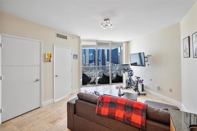 workout area featuring floor to ceiling windows, visible vents, and baseboards