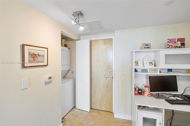 interior space featuring light tile patterned floors and stacked washer and dryer