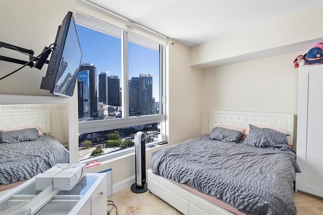 bedroom featuring light tile patterned flooring and baseboards