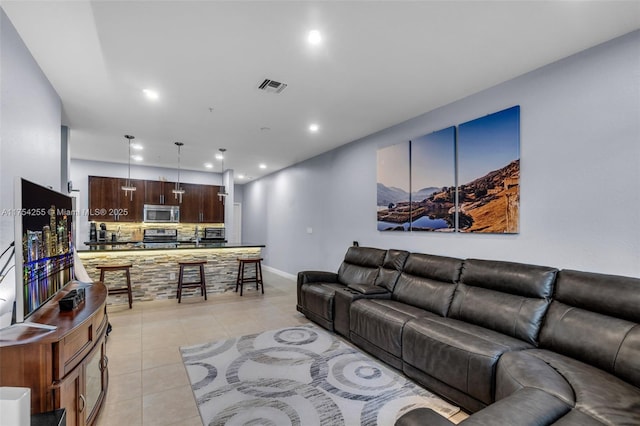 living room with light tile patterned floors, baseboards, visible vents, and recessed lighting