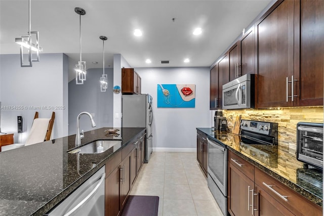 kitchen featuring visible vents, backsplash, appliances with stainless steel finishes, light tile patterned flooring, and a sink