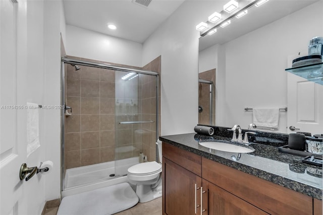 bathroom with a stall shower, vanity, toilet, and tile patterned floors