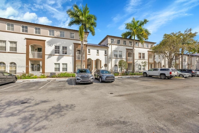 view of building exterior featuring a residential view and uncovered parking